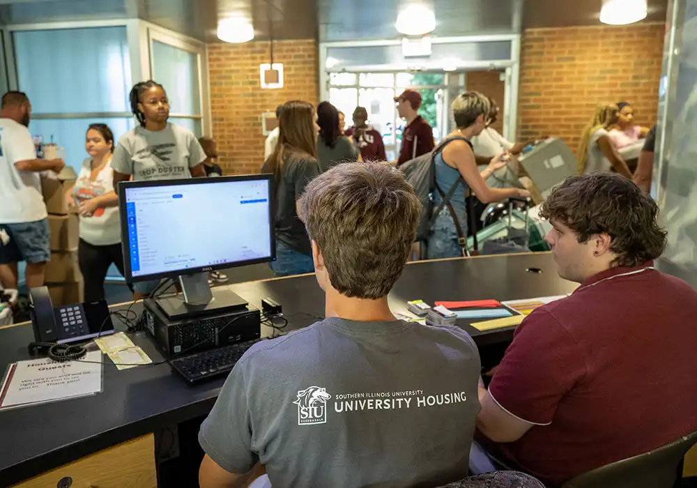 Students at the front desk assist residents during a busy move-in day.
