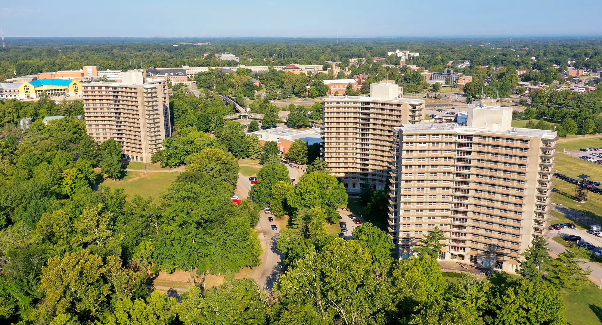 Aerial view of SIU’s high-rise residence halls surrounded by trees, campus buildings, and nearby roads.