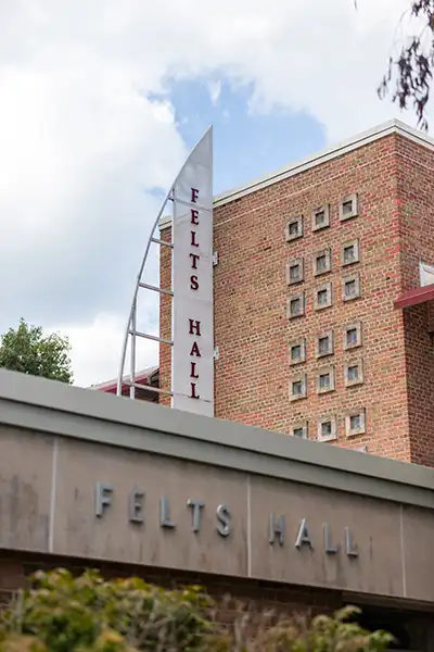 Exterior view of Felts Hall with its brick facade and vertical sign.